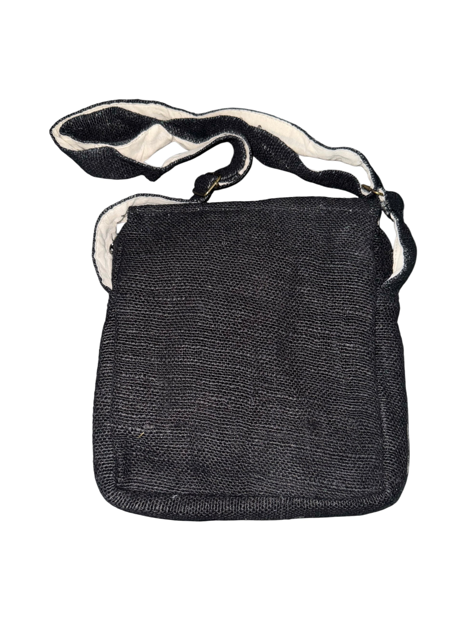 Black woven crossbody bag with wide adjustable strap and flap closure on white background
