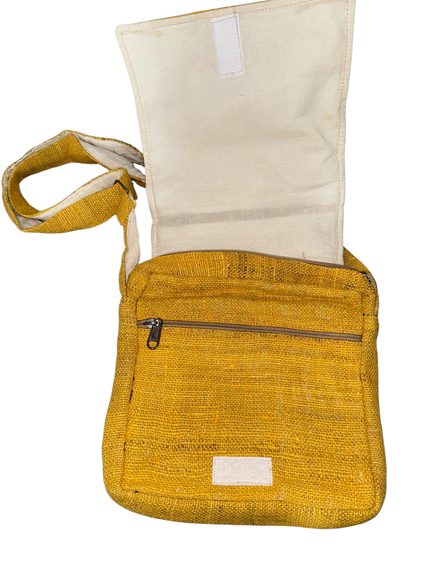 Yellow woven crossbody bag with flap open showing beige interior and front zipper pocket