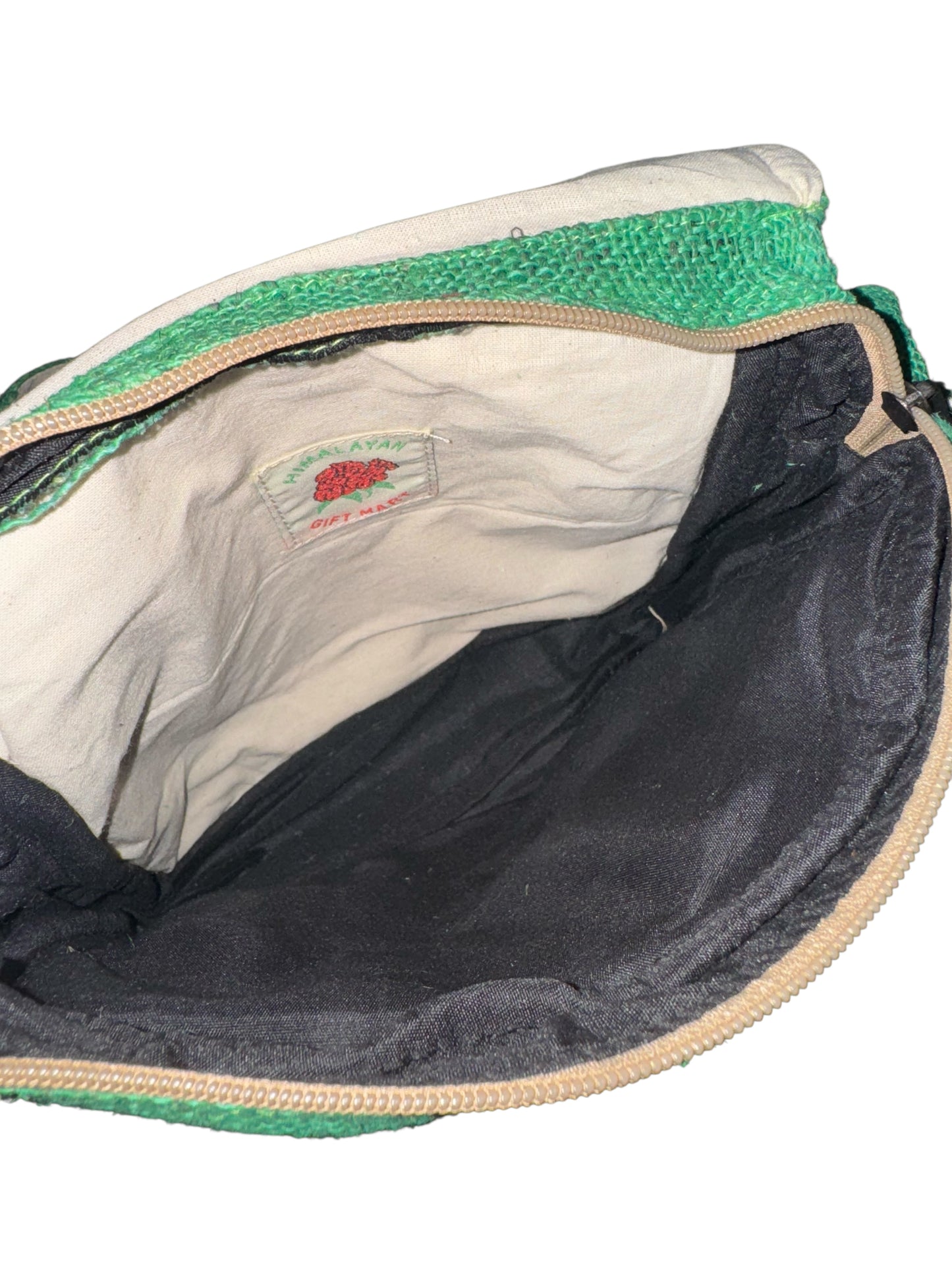 Inside view of green and beige Himalayan Gift Mart pouch with black inner lining and zipper