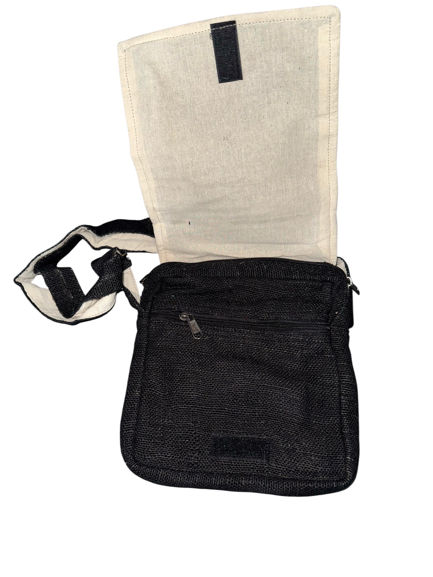 Black fabric crossbody bag with beige interior flap, zippered front pocket, and adjustable strap