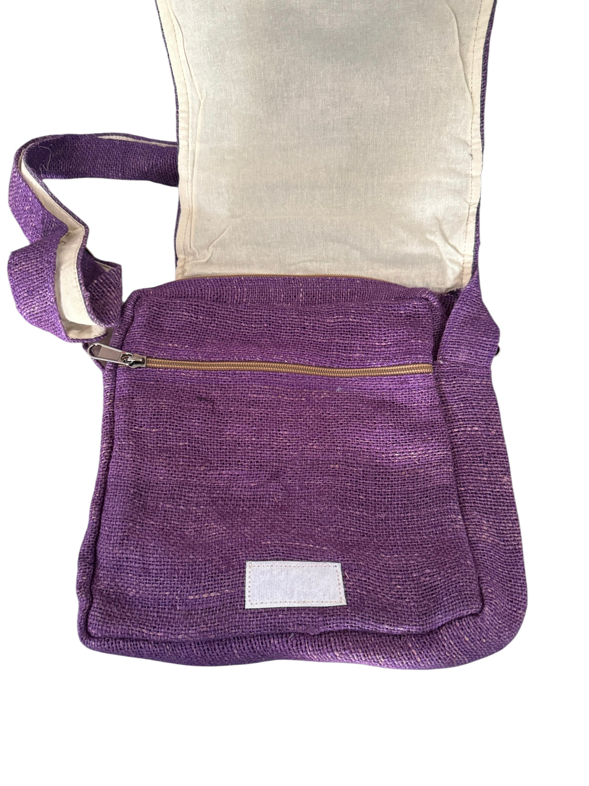 Purple woven crossbody bag with zipper pocket and beige inner lining, open flap visible